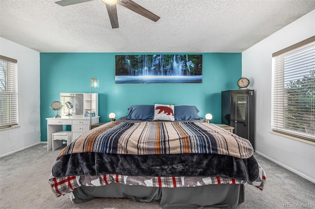 bedroom featuring a ceiling fan, carpet, a textured ceiling, and baseboards