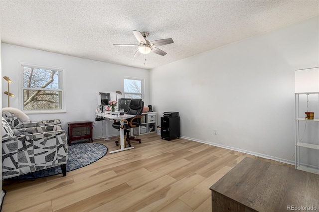 office area with ceiling fan, a textured ceiling, baseboards, and wood finished floors