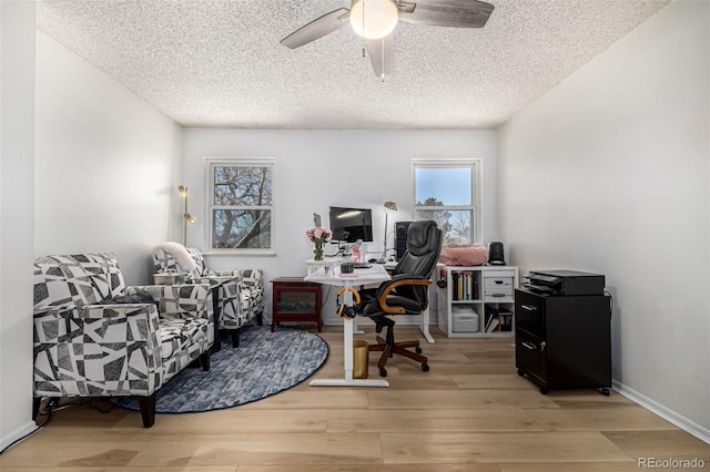 office area with a textured ceiling, ceiling fan, wood finished floors, and baseboards