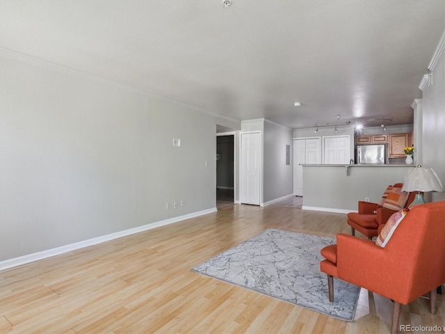 12348 W Dorado Pl Unit 204, Littleton, CO 80127 - living room with light wood finished floors, baseboards, crown molding, and rail lighting
