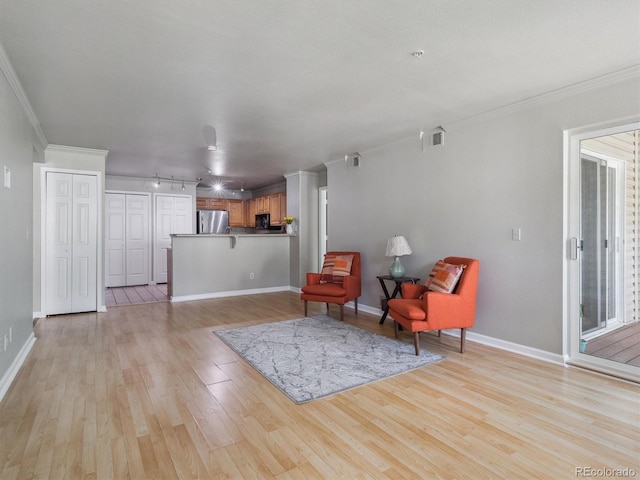 12348 W Dorado Pl Unit 204, Littleton, CO 80127 - living area featuring light wood finished floors, baseboards, and ornamental molding