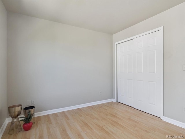 12348 W Dorado Pl Unit 204, Littleton, CO 80127 - unfurnished bedroom featuring light wood-style floors, baseboards, and a closet