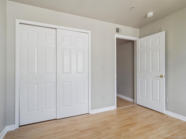 12348 W Dorado Pl Unit 204, Littleton, CO 80127 - unfurnished bedroom featuring baseboards, light wood-style flooring, and a closet