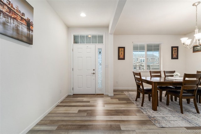 entryway with hardwood / wood-style floors and an inviting chandelier