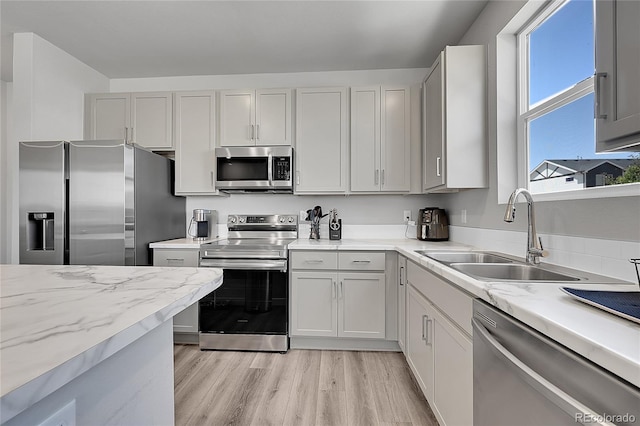 620 Apache Trl Unit A1, Ault, CO 80610 - kitchen featuring appliances with stainless steel finishes, light wood-type flooring, and light stone counters
