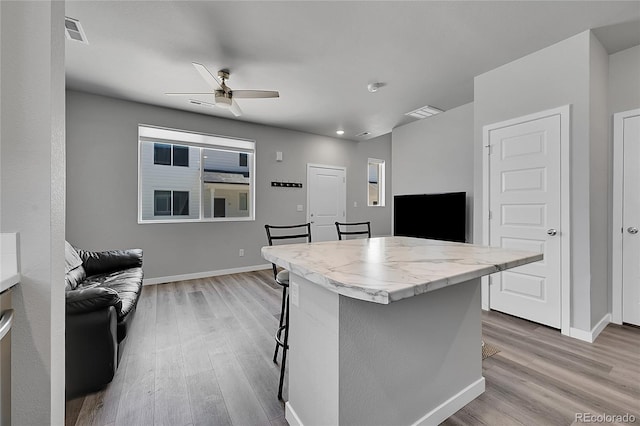620 Apache Trl Unit A1, Ault, CO 80610 - kitchen with light wood-style flooring, a ceiling fan, open floor plan, a kitchen bar, and recessed lighting