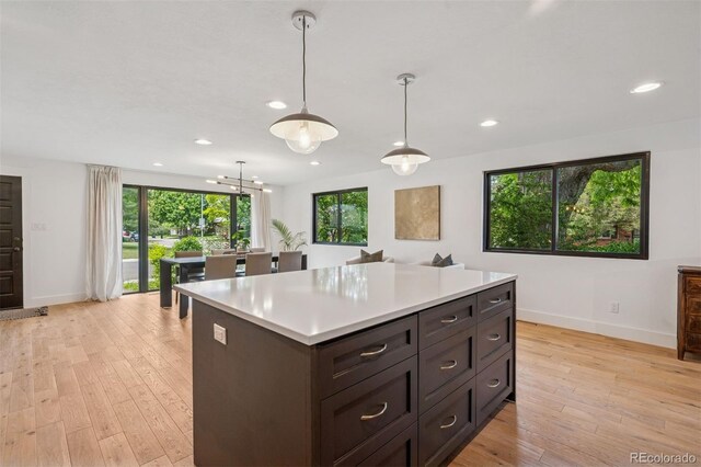 4634 W Tufts Cir, Denver, CO 80236 - kitchen featuring light countertops, recessed lighting, light wood finished floors, hanging light fixtures, and a kitchen island