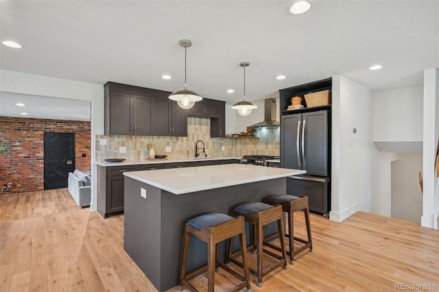 4634 W Tufts Cir, Denver, CO 80236 - kitchen featuring refrigerator, wall chimney range hood, light wood-style flooring, light countertops, and recessed lighting
