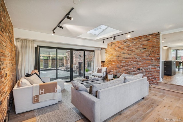 4634 W Tufts Cir, Denver, CO 80236 - living room with rail lighting, brick wall, a skylight, and light wood finished floors