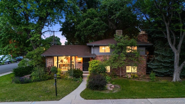 4634 W Tufts Cir, Denver, CO 80236 - view of front of home with brick siding, a yard, and a chimney