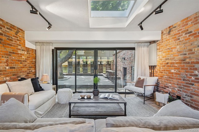 4634 W Tufts Cir, Denver, CO 80236 - living area featuring rail lighting, brick wall, a skylight, wood finished floors, and a fireplace