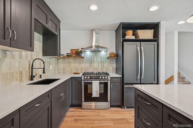4634 W Tufts Cir, Denver, CO 80236 - kitchen featuring appliances with stainless steel finishes, wall chimney range hood, light countertops, recessed lighting, and light wood-type flooring