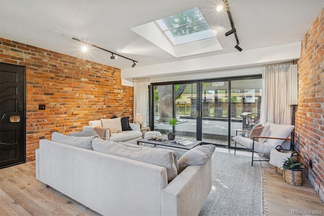 4634 W Tufts Cir, Denver, CO 80236 - living area with track lighting, a skylight, brick wall, and light wood-type flooring