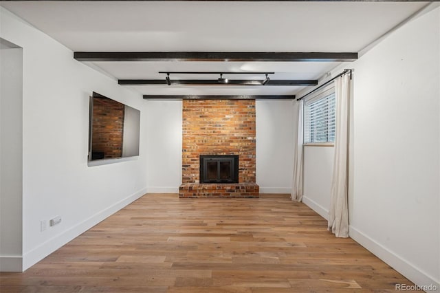 4634 W Tufts Cir, Denver, CO 80236 - unfurnished living room with beam ceiling, light wood-type flooring, and a fireplace