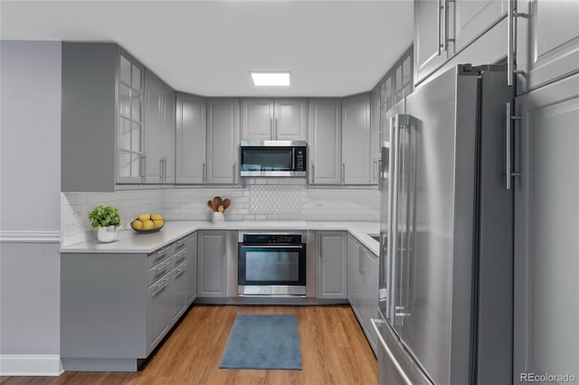 kitchen featuring gray cabinetry, stainless steel appliances, and light hardwood / wood-style flooring