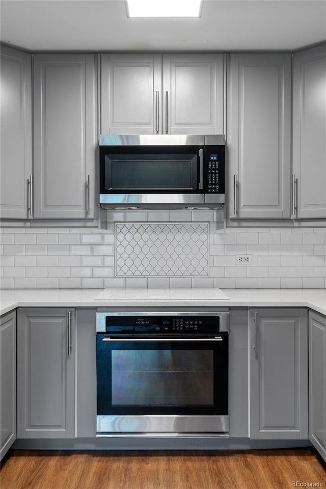 kitchen featuring tasteful backsplash, light wood-type flooring, and stainless steel appliances