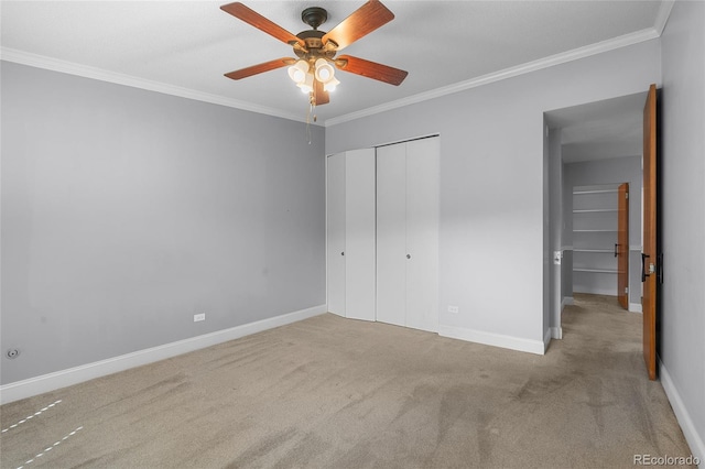 unfurnished bedroom featuring ceiling fan, crown molding, a closet, and light carpet