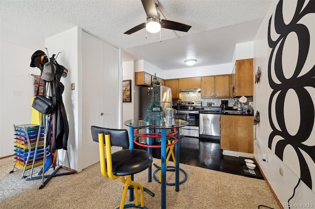 kitchen with stainless steel appliances, a textured ceiling, ceiling fan, and decorative backsplash