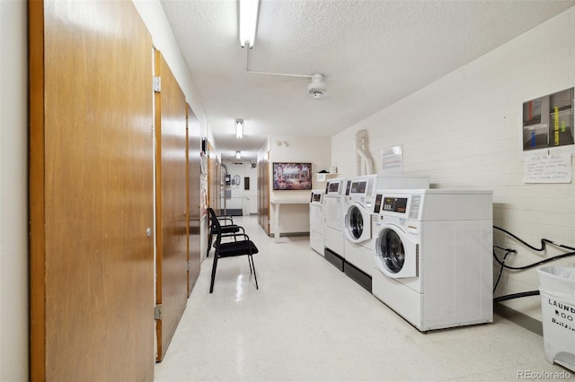 laundry room featuring washing machine and dryer and a textured ceiling