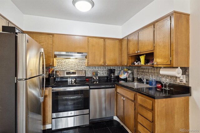 kitchen featuring tasteful backsplash, dark countertops, appliances with stainless steel finishes, a sink, and extractor fan