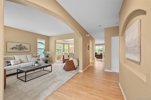 18967 W 54th Ln, Golden, CO 80403 - living room featuring light wood-type flooring, arched walkways, and baseboards