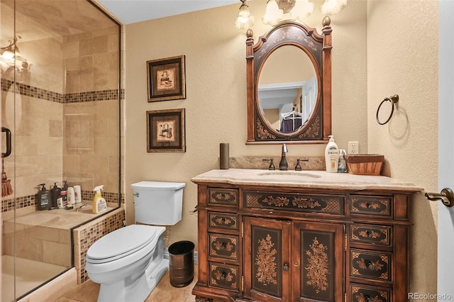 18967 W 54th Ln, Golden, CO 80403 - bathroom with vanity, toilet, a shower stall, a textured wall, and tile patterned flooring