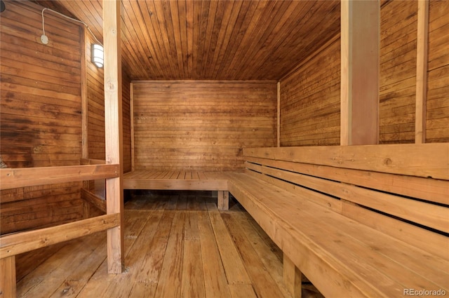 view of sauna with wood walls, hardwood / wood-style floors, and wood ceiling