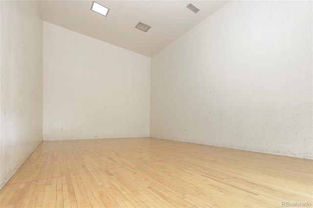 spare room with light hardwood / wood-style floors and lofted ceiling