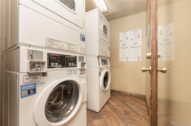 washroom featuring hardwood / wood-style flooring, washer and clothes dryer, and stacked washer / dryer