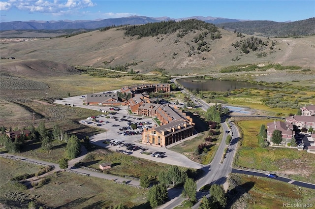 drone / aerial view featuring a water and mountain view