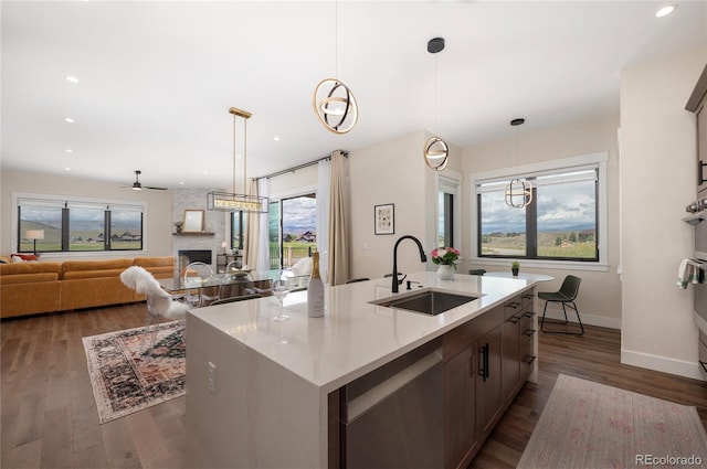 kitchen featuring pendant lighting, dishwasher, a kitchen island with sink, sink, and ceiling fan