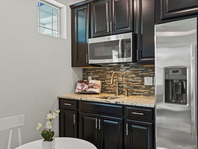 5445 Verbena St, Denver, CO 80238 - kitchen featuring stainless steel appliances, backsplash, and light stone countertops