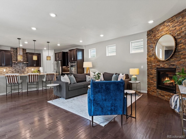 5445 Verbena St, Denver, CO 80238 - living room featuring dark wood-style flooring, recessed lighting, and a stone fireplace