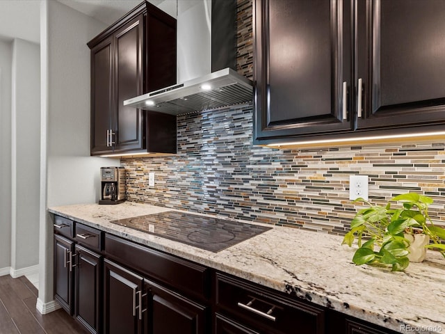 5445 Verbena St, Denver, CO 80238 - kitchen featuring wall chimney range hood, black electric cooktop, dark brown cabinets, light stone counters, and dark wood finished floors