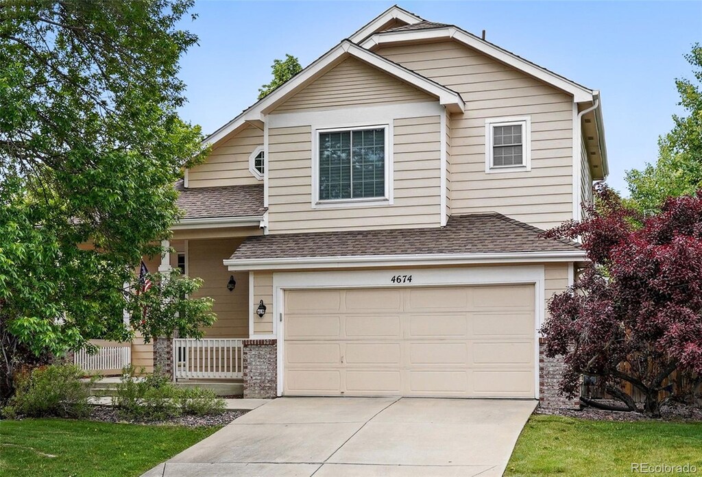 4674 Winona Pl, Broomfield, CO 80020 - traditional home featuring a garage, roof with shingles, concrete driveway, a front lawn, and brick siding