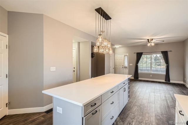 kitchen featuring ceiling fan, pendant lighting, a center island, white cabinets, and dark hardwood / wood-style flooring