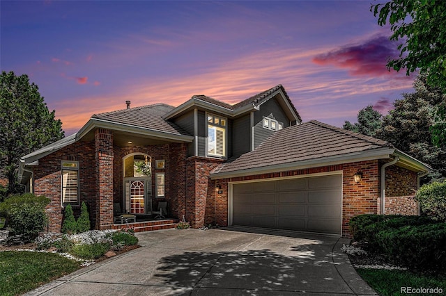 6500 W Mansfield Ave Unit 39, Denver, CO 80235 - traditional-style house with driveway, brick siding, a garage, and a tile roof