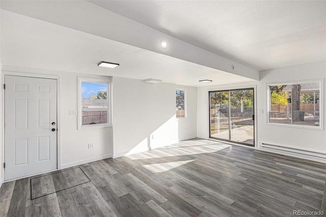 interior space with a wealth of natural light, wood-type flooring, and a baseboard radiator