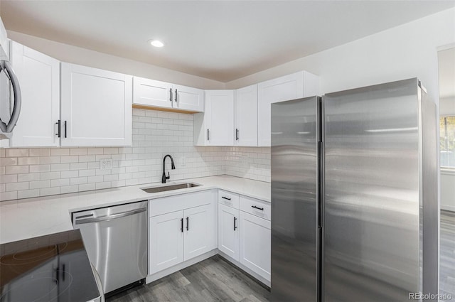 kitchen with white cabinets, appliances with stainless steel finishes, dark wood-type flooring, and sink