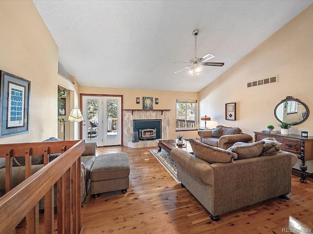 living room featuring a textured ceiling, hardwood / wood-style floors, ceiling fan, and high vaulted ceiling