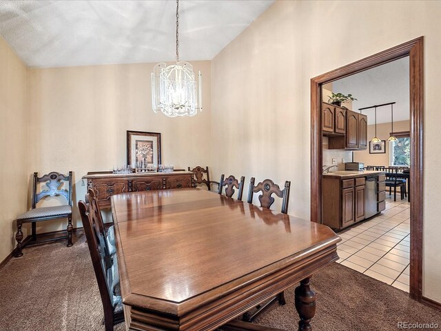 dining area with a notable chandelier, light carpet, and sink