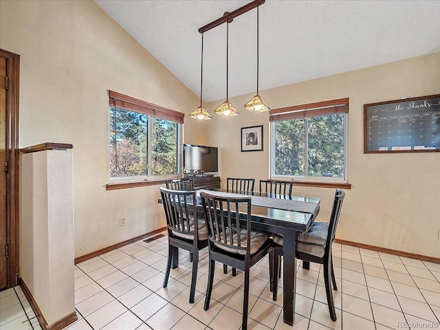 dining space with lofted ceiling, a textured ceiling, and light tile patterned flooring