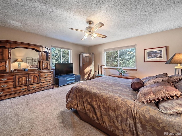 bedroom with carpet flooring, a textured ceiling, multiple windows, and ceiling fan