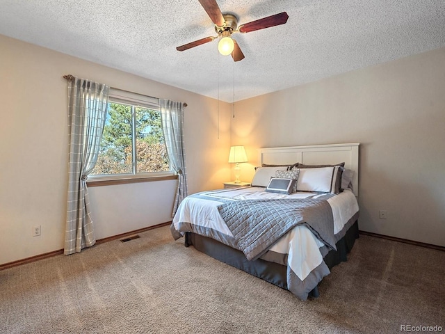 bedroom with ceiling fan, a textured ceiling, and carpet