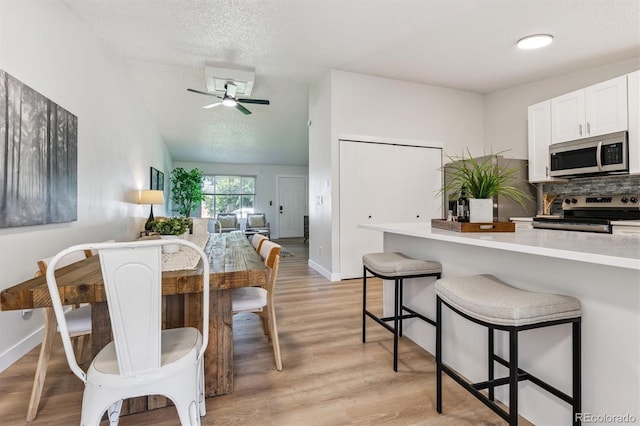 1418 5th St, Fort Lupton, CO 80621 - dining room featuring light wood-type flooring, a ceiling fan, and a textured ceiling