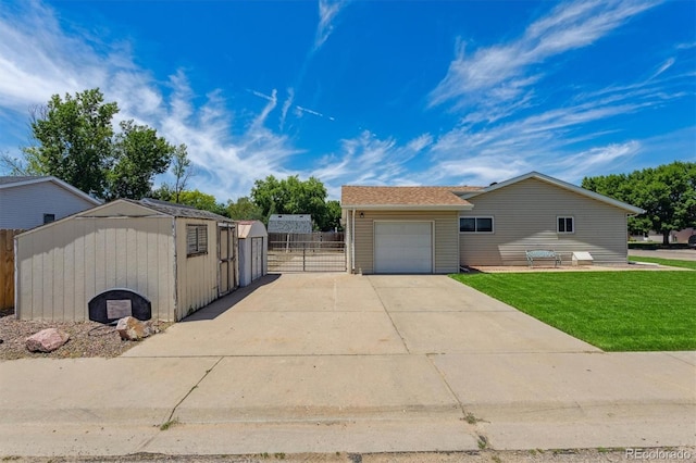 1418 5th St, Fort Lupton, CO 80621 - view of front facade featuring concrete driveway, a gate, and a shed