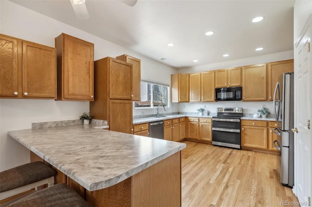 2336 Klein Pl, Colorado Springs, CO 80951 - kitchen featuring light wood-style floors, a breakfast bar, a peninsula, appliances with stainless steel finishes, and recessed lighting