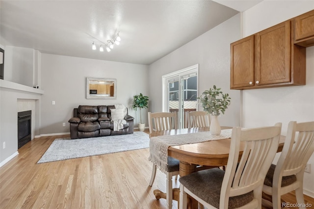 2336 Klein Pl, Colorado Springs, CO 80951 - dining space featuring a glass covered fireplace, light wood finished floors, and baseboards