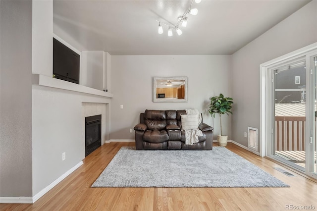 2336 Klein Pl, Colorado Springs, CO 80951 - living room with plenty of natural light, visible vents, baseboards, wood finished floors, and a tile fireplace