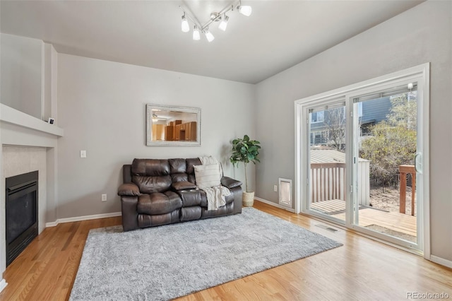 2336 Klein Pl, Colorado Springs, CO 80951 - living room featuring light wood finished floors, a glass covered fireplace, baseboards, and visible vents
